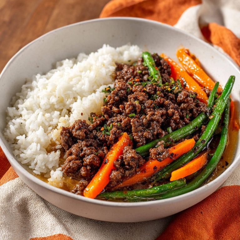 Asiatische Hackfleisch-Bowl mit Reis und Gemüse serviert in einer Schüssel. Die Hackfleisch-Bowl wird mit frisch gekochtem Reis und Gemüse serviert.
