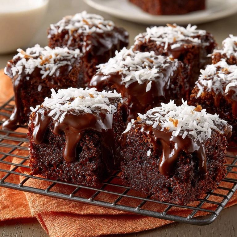 Kokos-Schoko-Brownies auf einem Kühlgitter präsentiert, mit geschmolzener Schokoladenglasur und Kokosraspeln garniert.