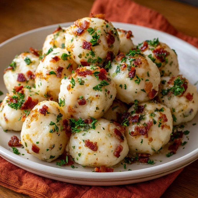 Kartoffelknödel mit knusprigem Speck in einer Draufsicht serviert, mit knusprigem Speck und frischer Petersilie garniert. Ein herzhaftes, traditionelles Gericht.
