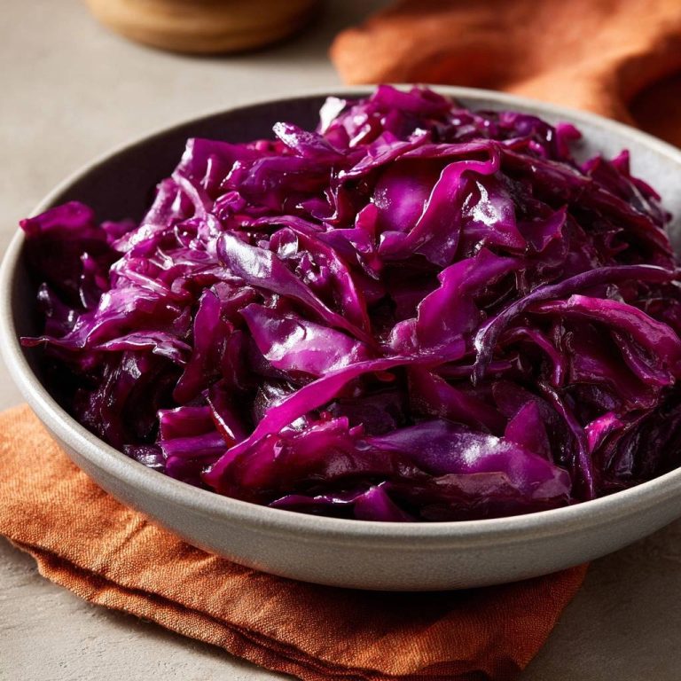 Knackiger Rotkohl in einer grauen Schüssel, serviert und von oben fotografiert, mit leuchtend violetten Kohlblättern.