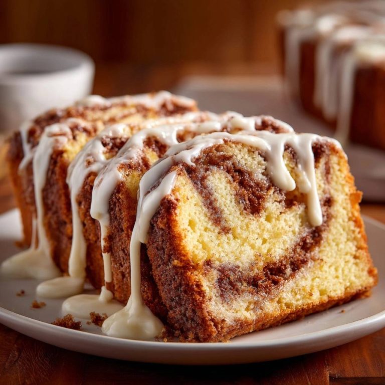 Zimtschnecken-Kuchen zeigt angeschnittene Scheiben mit deutlichen Zimtwirbeln und Zuckerguss.