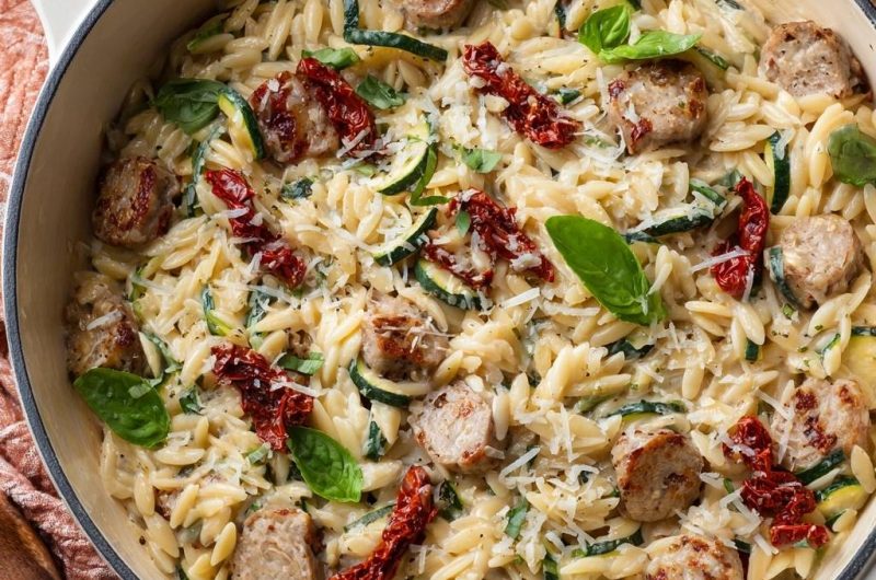 Cremiges Zucchini-Orzo mit Wurst und Tomaten