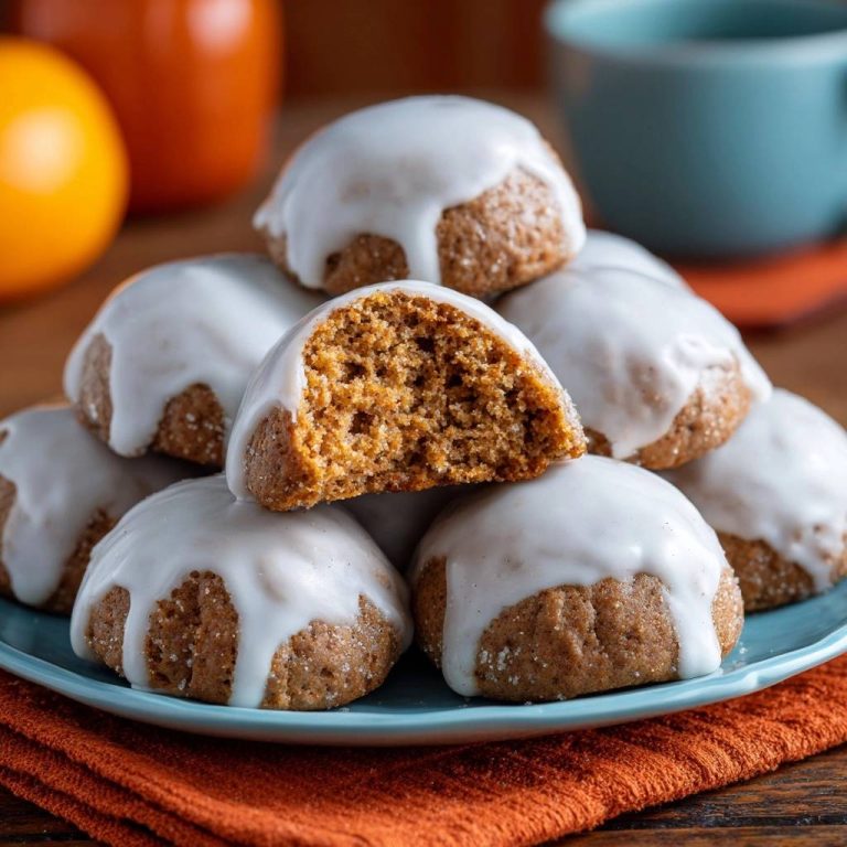Herbstliche Kürbiskekse mit Zuckerguss zeigen hier einen appetitlichen Querschnitt, der die lockere Textur und den Geschmack offenbart.