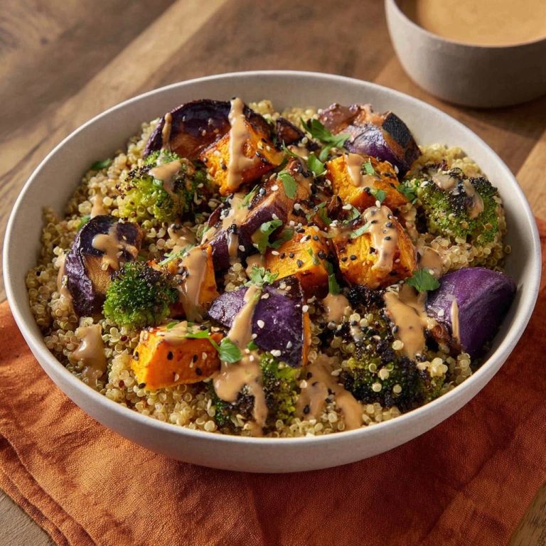 Knusprige Quinoa-Gemüse-Bowl mit Erdnuss-Sauce, serviert in einer Schüssel, mit geröstetem Gemüse und einem köstlichen Erdnuss-Dressing.